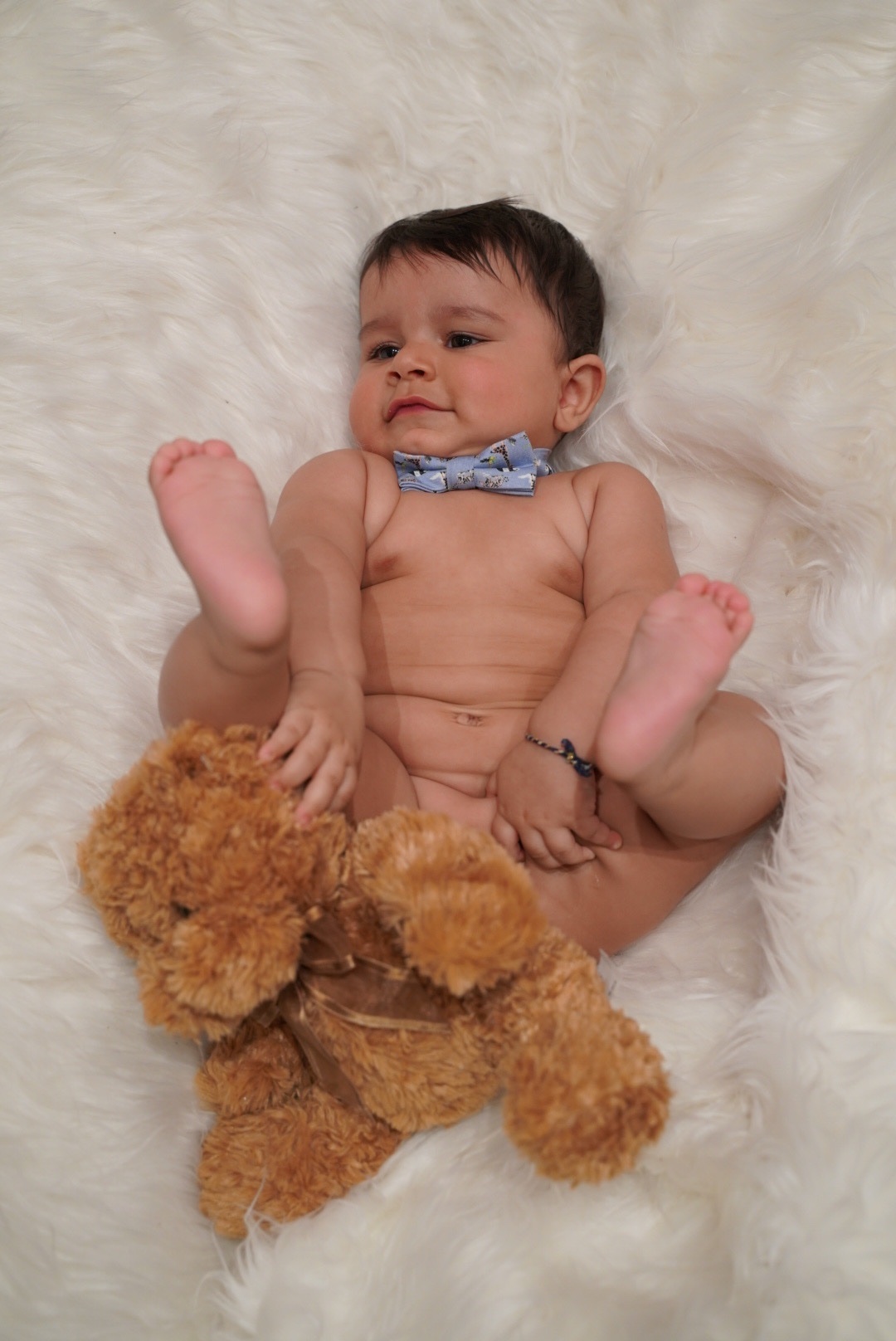 Baby portrait with a bow tie and teddy bear prop