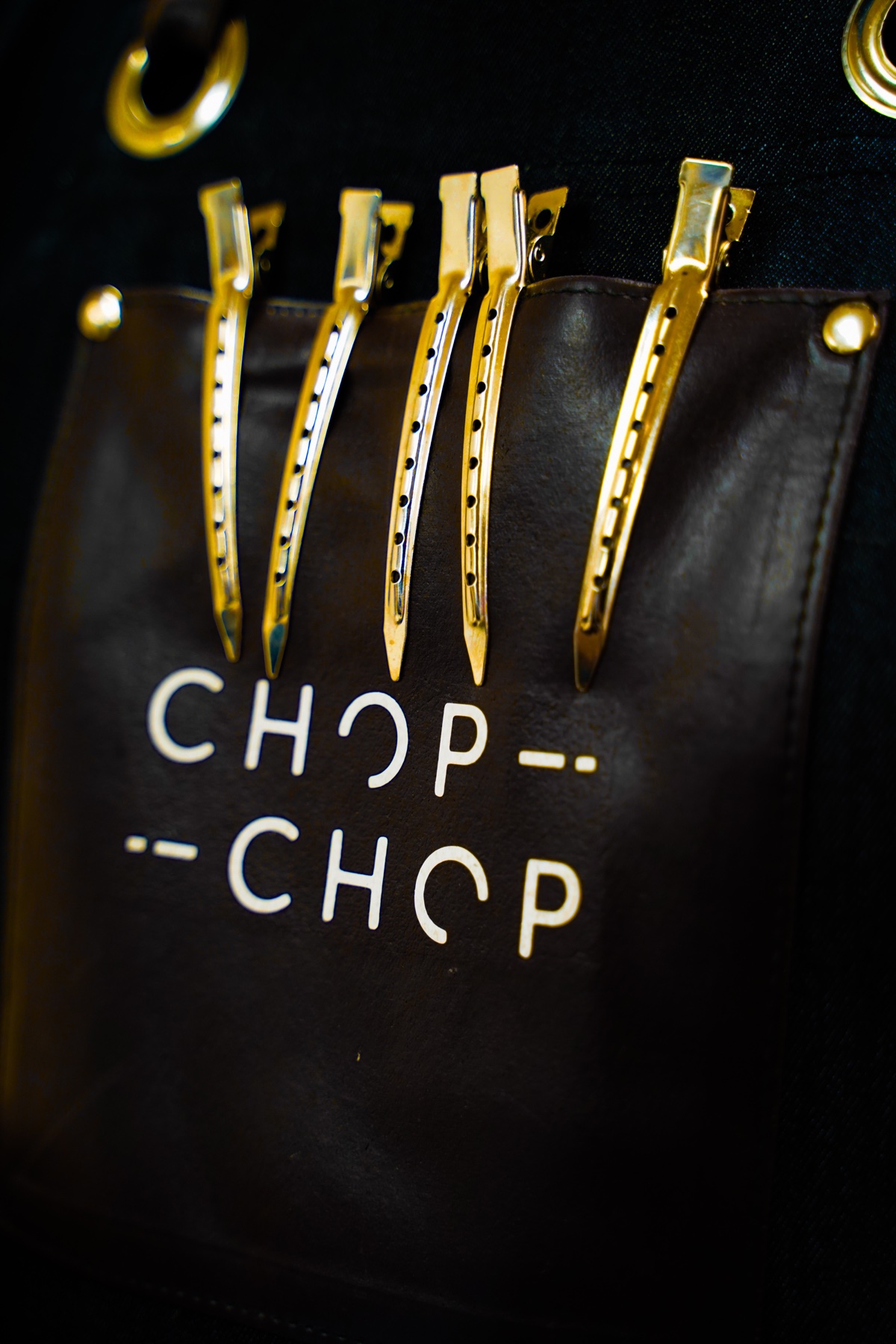 Gold hair clips arranged over Chop Chop branding