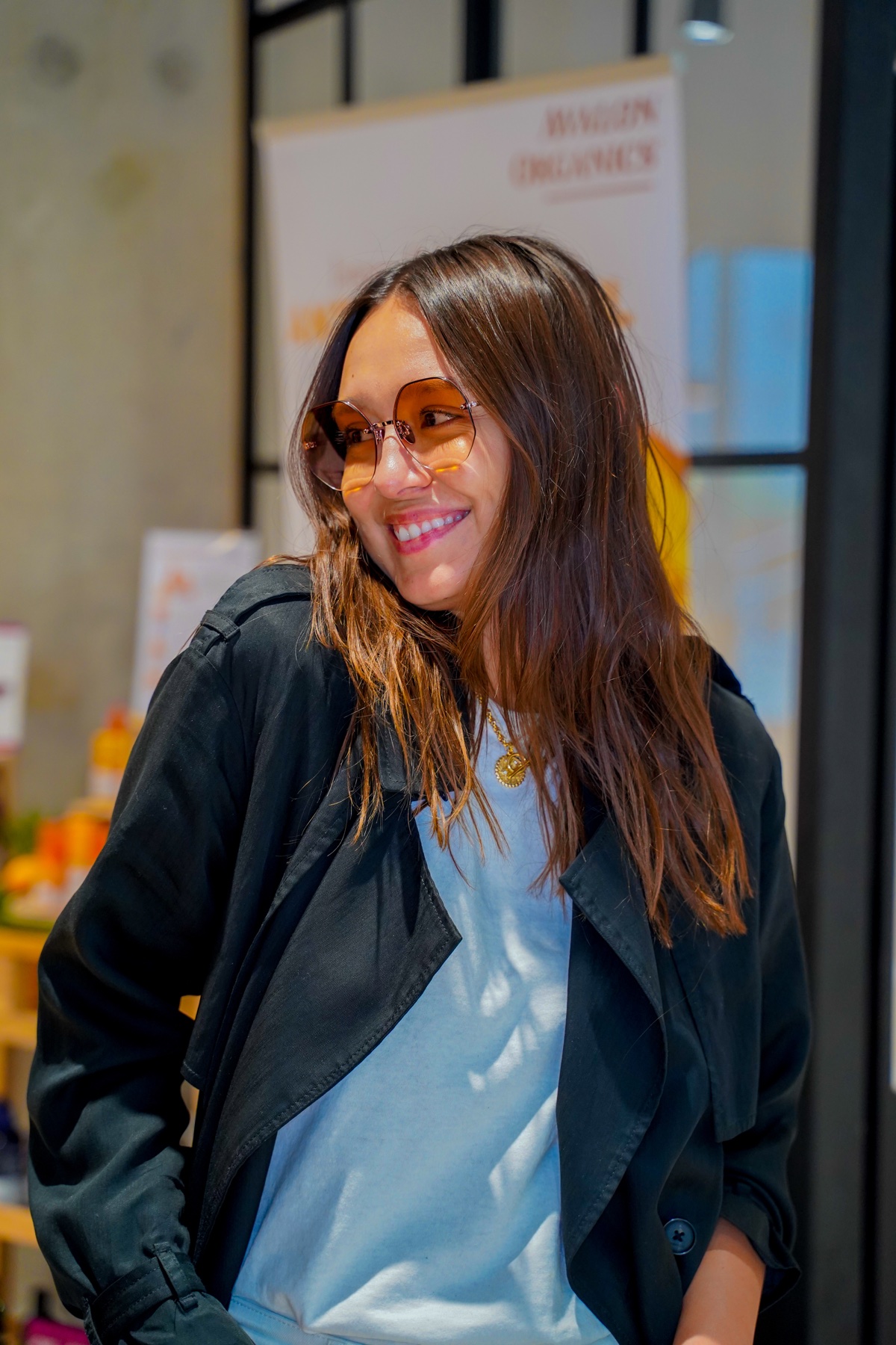 Woman modelling amber-tinted sunglasses at a brand event