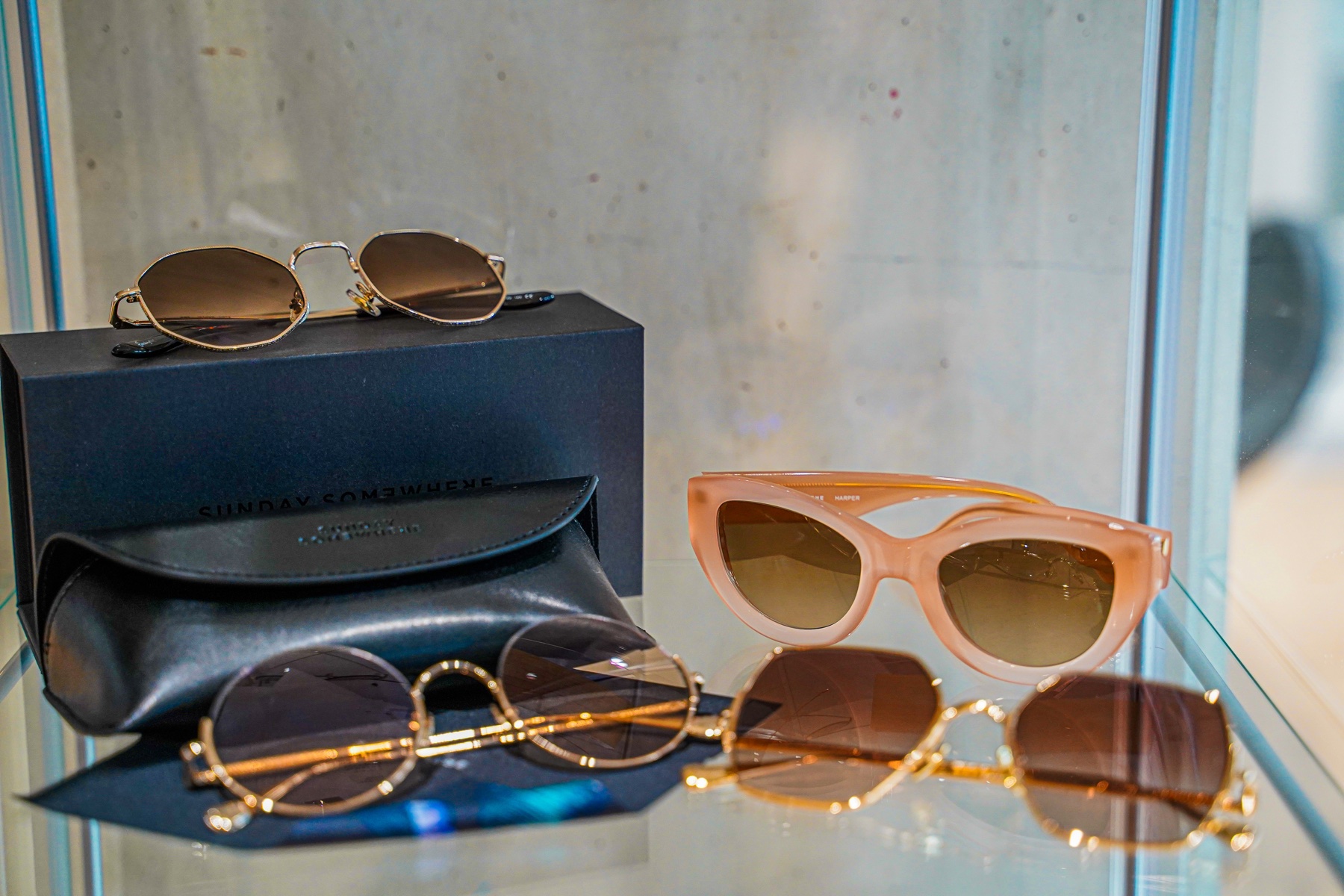 Designer sunglasses and branded cases arranged in a retail display